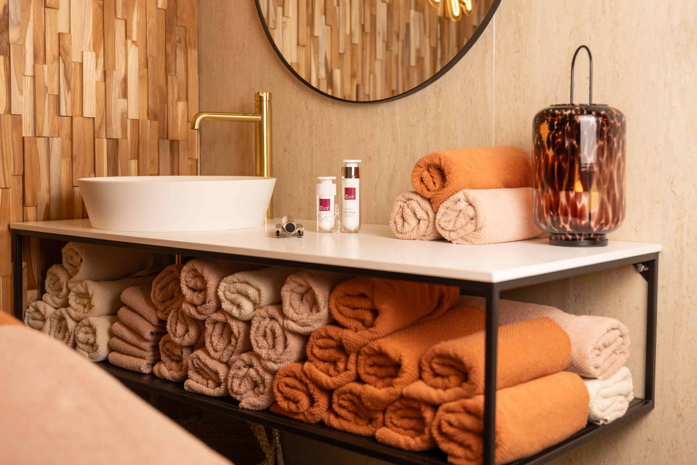 Het warme interieur van de salon met gouden kraan en zachte handdoeken